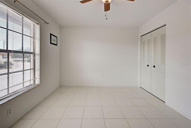 unfurnished bedroom featuring ceiling fan, a closet, and light tile patterned floors