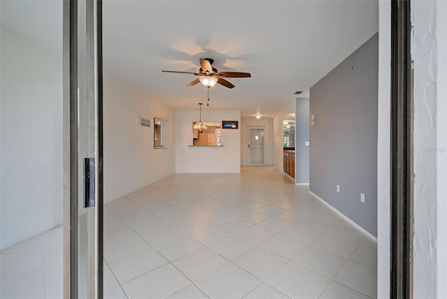 unfurnished living room with ceiling fan and light tile patterned floors