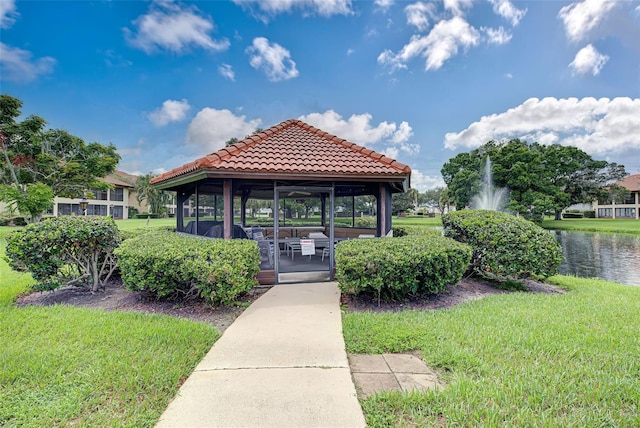 view of property's community with a water view, a gazebo, and a lawn