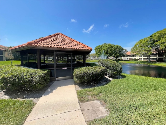 view of property's community with a water view and a yard