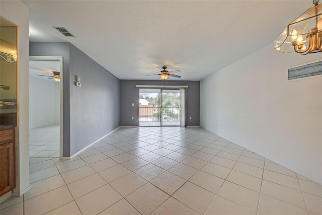 unfurnished room with ceiling fan with notable chandelier, light tile patterned floors, and a textured ceiling