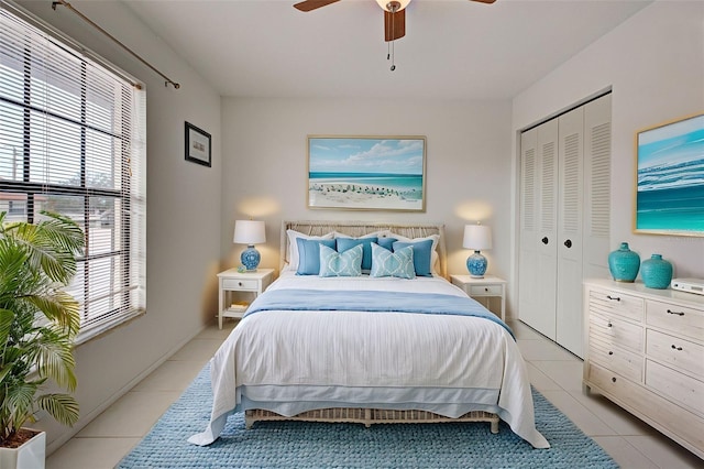 tiled bedroom featuring ceiling fan and a closet