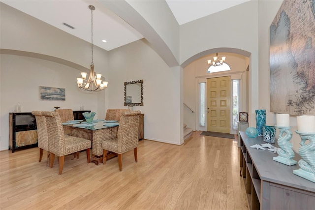 dining room featuring lofted ceiling, light hardwood / wood-style flooring, and a chandelier