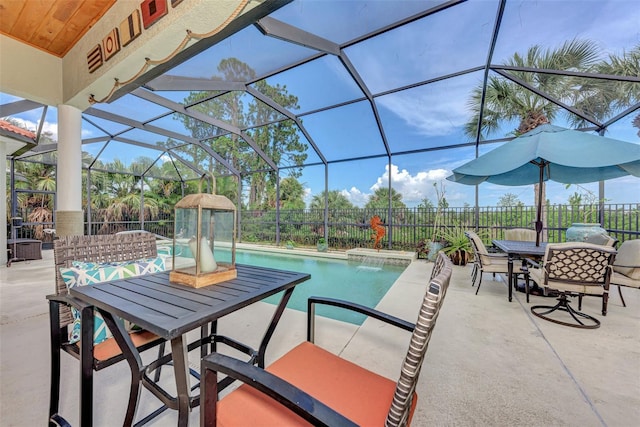 view of swimming pool featuring a patio area, pool water feature, and glass enclosure