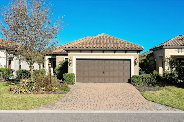 mediterranean / spanish home featuring a front yard and a garage