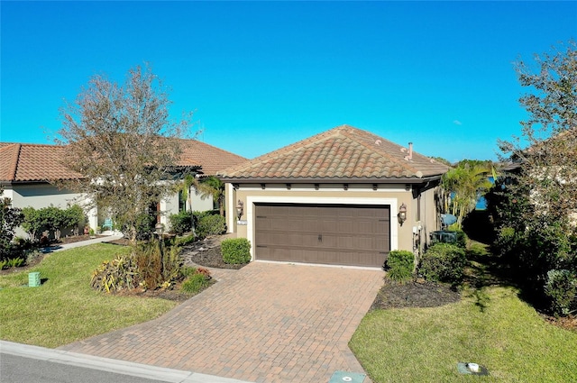 mediterranean / spanish home with a front yard and a garage