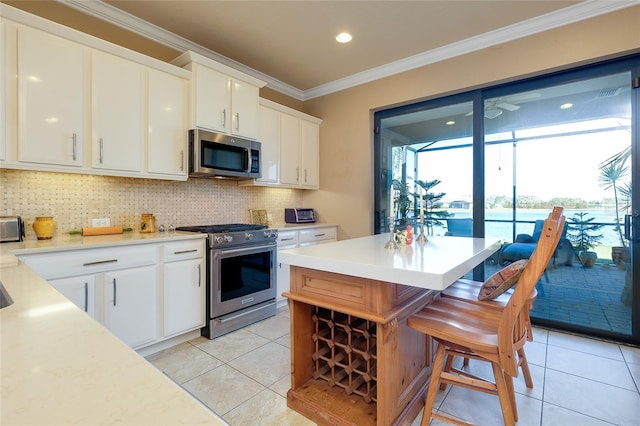 kitchen with appliances with stainless steel finishes, crown molding, white cabinetry, and tasteful backsplash