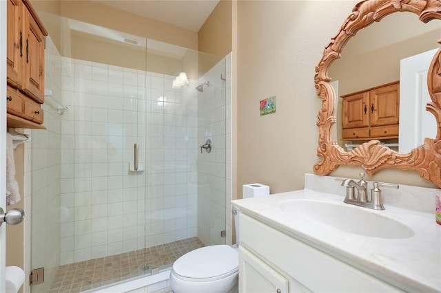 bathroom featuring vanity, toilet, and an enclosed shower