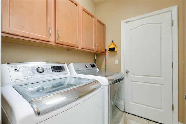 laundry room featuring cabinets, washer and dryer, and light tile patterned floors