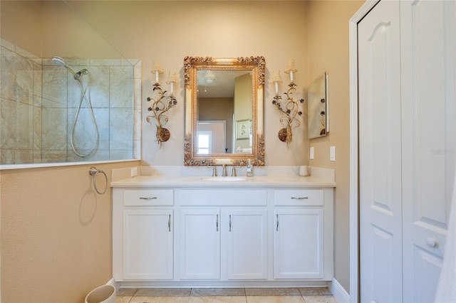 bathroom featuring a tile shower, tile patterned flooring, and vanity