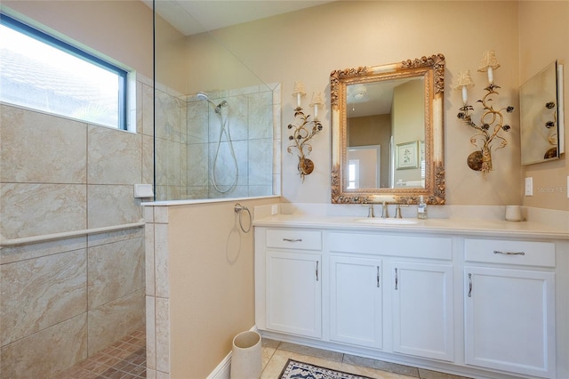 bathroom featuring vanity, a tile shower, and tile patterned floors