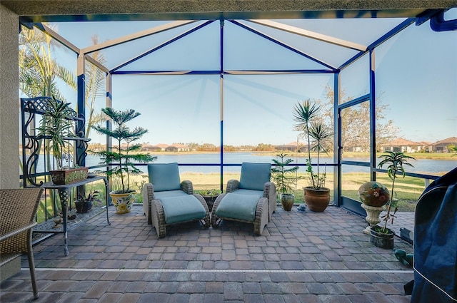 view of patio / terrace featuring a water view and glass enclosure