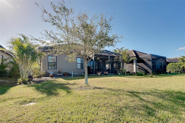 back of house featuring a yard and glass enclosure