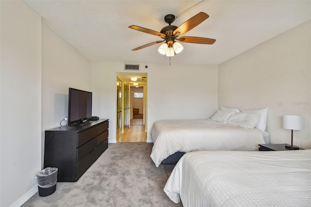 carpeted bedroom with ceiling fan and a textured ceiling