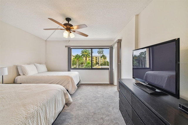 bedroom featuring ceiling fan, light colored carpet, and a textured ceiling