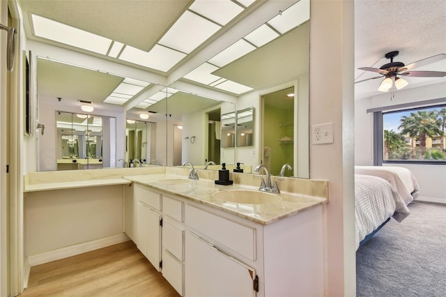 bathroom with ceiling fan, vanity, and hardwood / wood-style flooring