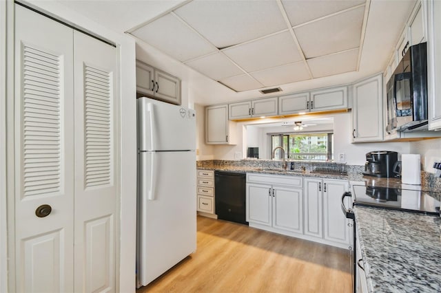 kitchen with sink, electric stove, white refrigerator, black dishwasher, and light hardwood / wood-style floors