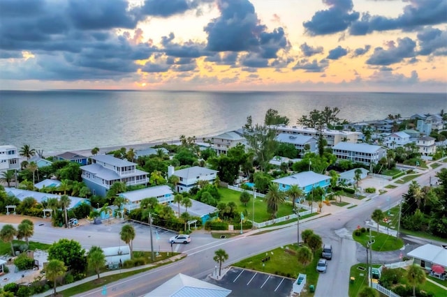 aerial view at dusk featuring a water view