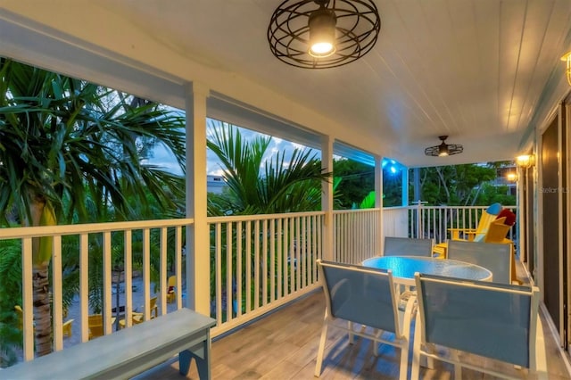 deck with ceiling fan and a water view