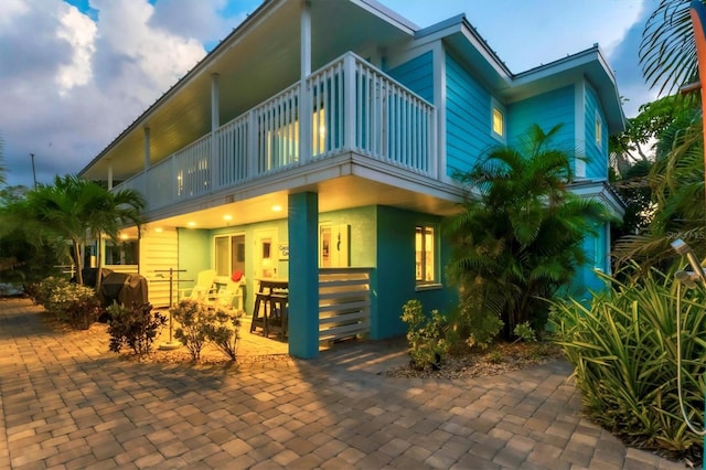 view of front of property featuring a balcony and a patio