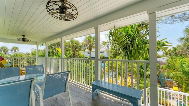 sunroom with ceiling fan and wooden ceiling