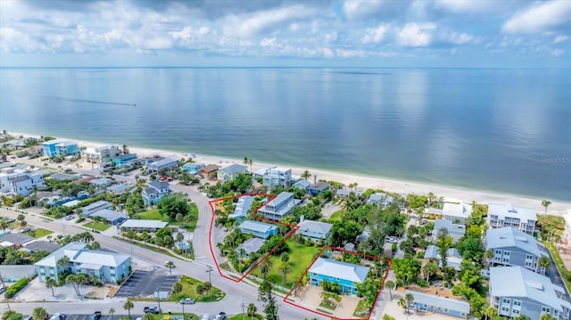 birds eye view of property featuring a beach view and a water view