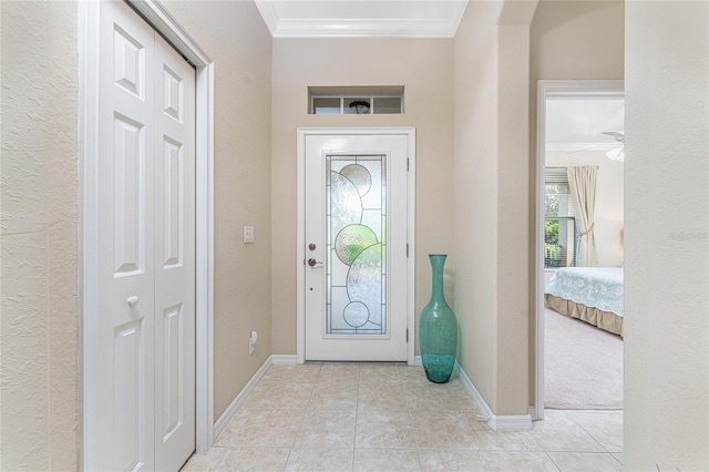 tiled foyer entrance featuring ceiling fan and crown molding