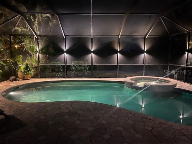 view of pool featuring an in ground hot tub and a lanai