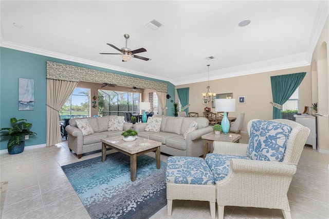 tiled living room with ceiling fan with notable chandelier and ornamental molding