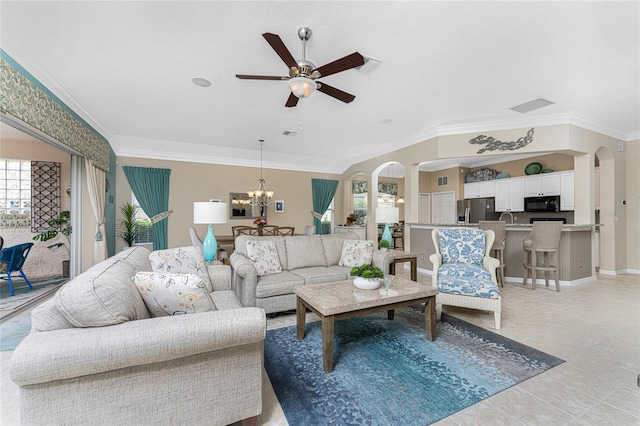 tiled living room featuring ceiling fan with notable chandelier, a healthy amount of sunlight, ornamental molding, and sink