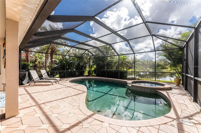 view of pool with an in ground hot tub, a patio, a water view, and glass enclosure