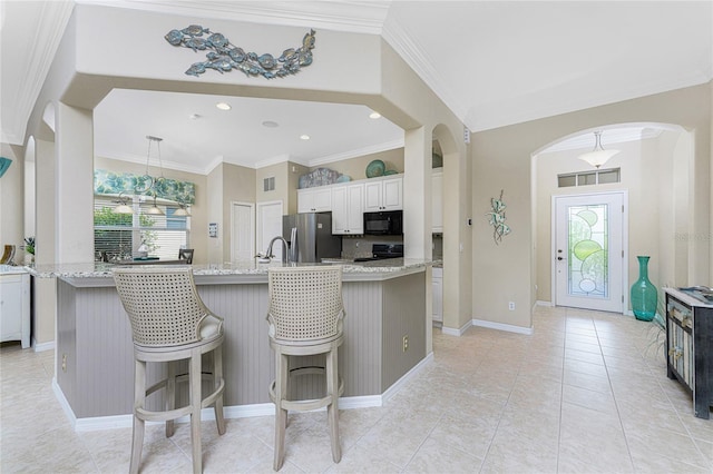 105 Treviso Ct, North Venice, FL 34275 - kitchen with black microwave, stainless steel refrigerator with ice dispenser, arched walkways, range with electric cooktop, and crown molding