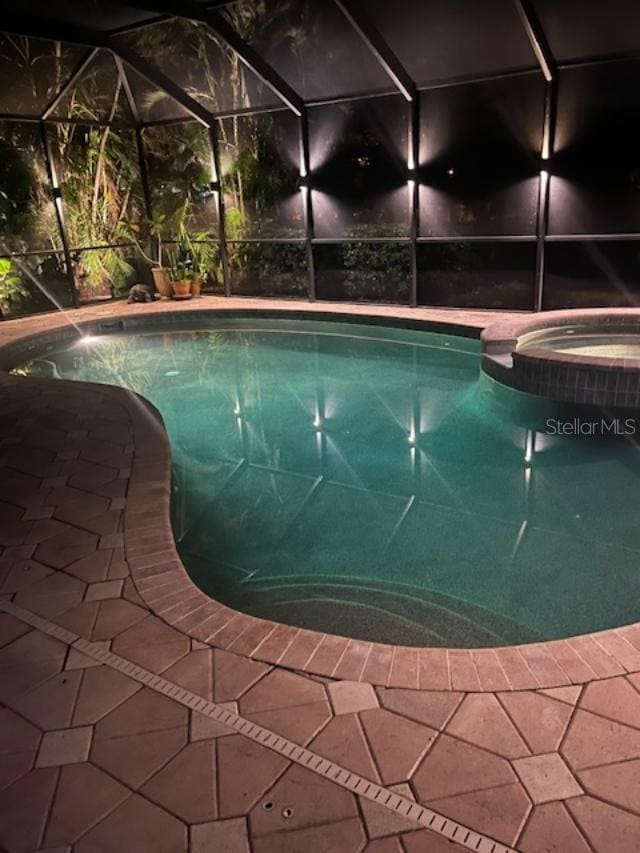 view of swimming pool featuring an in ground hot tub and glass enclosure