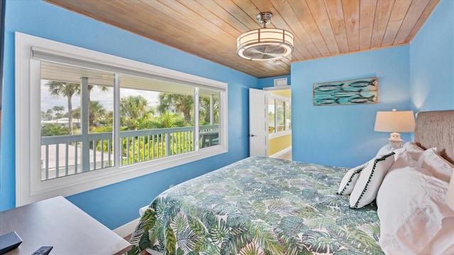 bedroom with multiple windows and wooden ceiling