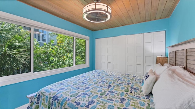 bedroom with multiple closets and wood ceiling