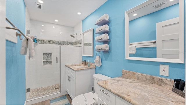 bathroom featuring a shower with door, vanity, wood-type flooring, and toilet