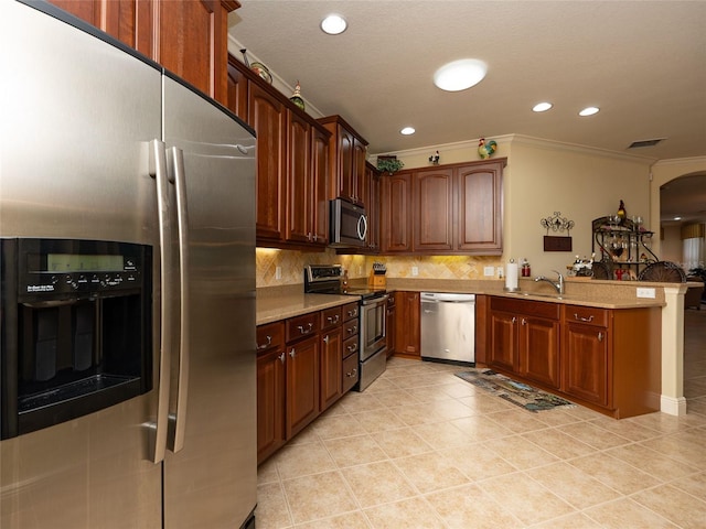 kitchen featuring tasteful backsplash, ornamental molding, appliances with stainless steel finishes, sink, and kitchen peninsula