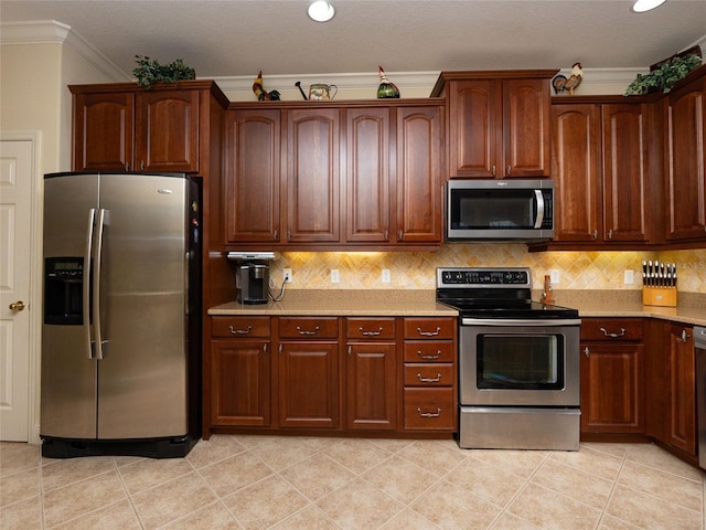 kitchen with ornamental molding, stainless steel appliances, light tile patterned floors, and backsplash