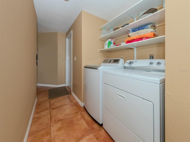 clothes washing area featuring washing machine and dryer and light tile patterned floors