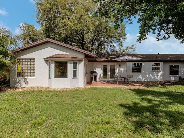 back of house with a lawn and a patio area