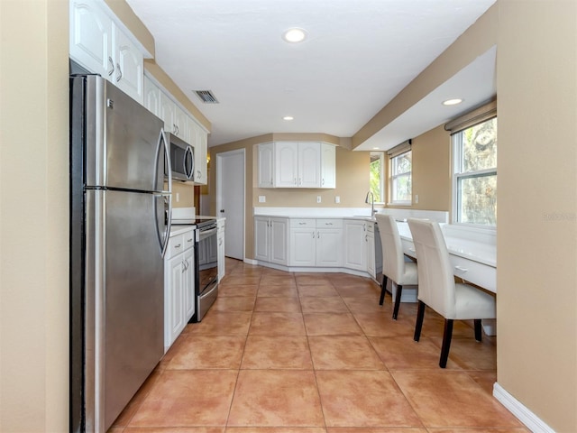 kitchen featuring white cabinets, light tile patterned floors, and appliances with stainless steel finishes