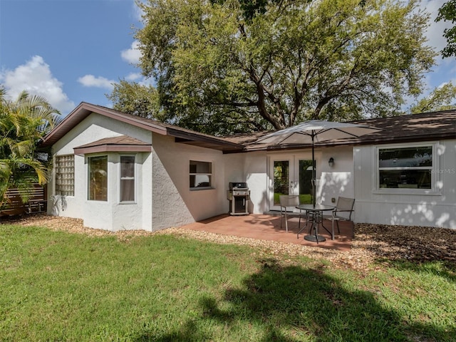 back of property with a patio and a lawn