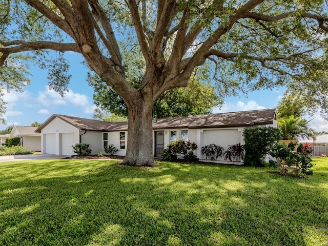 single story home featuring a garage and a front lawn