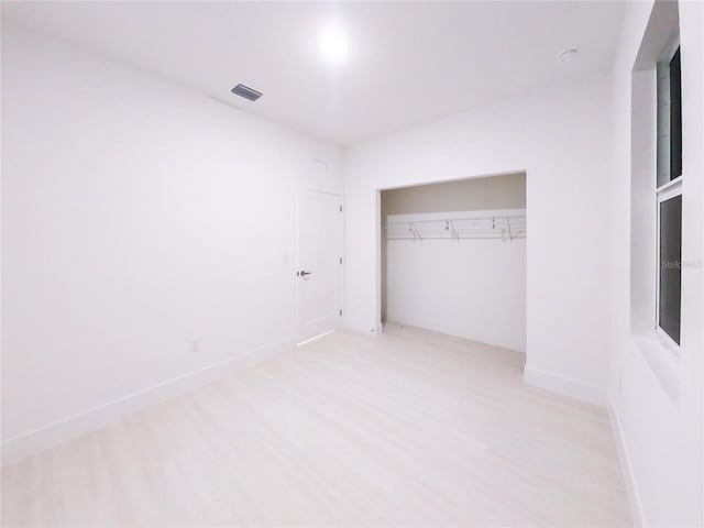 unfurnished bedroom featuring a closet and light hardwood / wood-style flooring