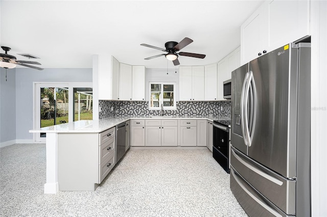 kitchen featuring white cabinets, kitchen peninsula, stainless steel appliances, and decorative backsplash