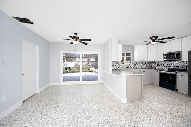 kitchen with tasteful backsplash, white cabinetry, appliances with stainless steel finishes, sink, and kitchen peninsula