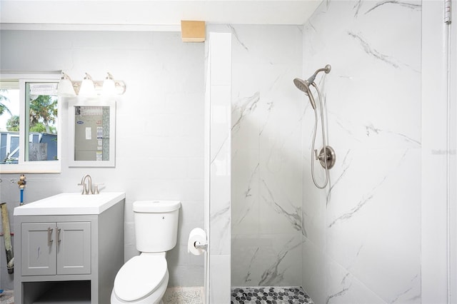 bathroom featuring vanity, toilet, and tiled shower