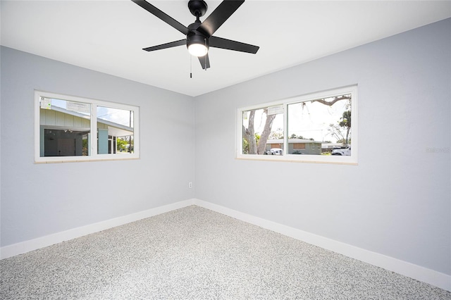 spare room featuring a wealth of natural light, ceiling fan, and carpet