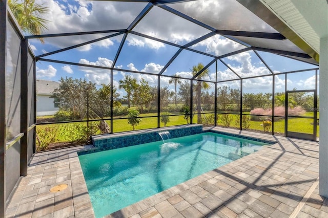 view of swimming pool featuring a lanai, a lawn, pool water feature, and a patio area