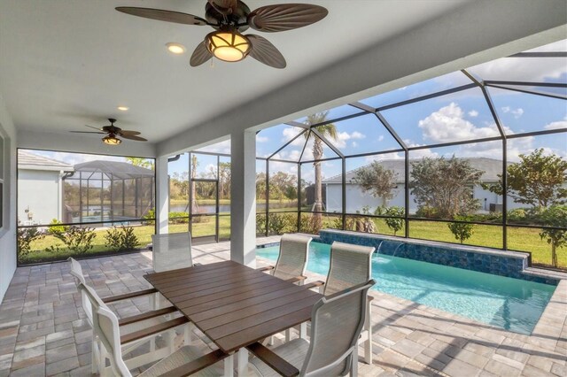 view of swimming pool with ceiling fan, a patio, pool water feature, and glass enclosure